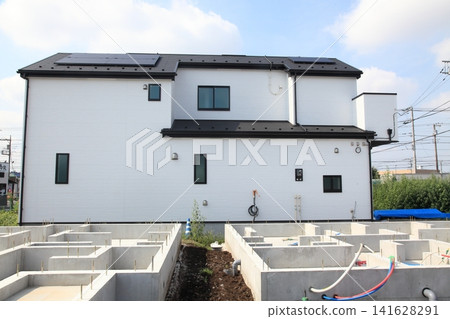 A newly built house that is one step away from completion and a detached house where foundation work has begun. A newly built house that is one step away from completion and a detached house where foundation work has begun. 141628291