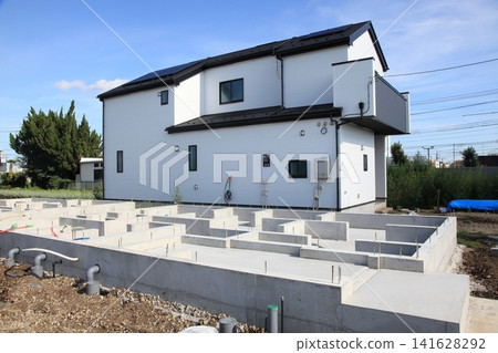 A newly built house that is one step away from completion and a detached house where foundation work has begun. A newly built house that is one step away from completion and a detached house where foundation work has begun. 141628292