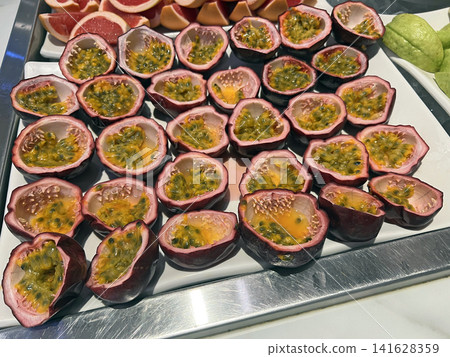 Photographing the neatly arranged passion fruits at the fruit bar in the self-service restaurant. Photographing the neatly arranged passion fruits at the fruit bar in the self-service restaurant. 141628359