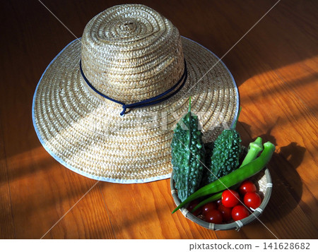 Fresh summer vegetables harvested from the home garden and a straw hat Fresh summer vegetables harvested from the home garden and a straw hat 141628682