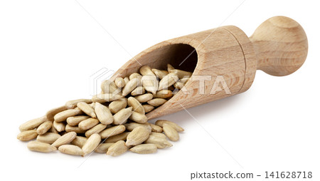 Oat groats spilling from a wooden spatula, close-up on a white background. Isolated Oat groats spilling from a wooden spatula, close-up on a white background. Isolated 141628718