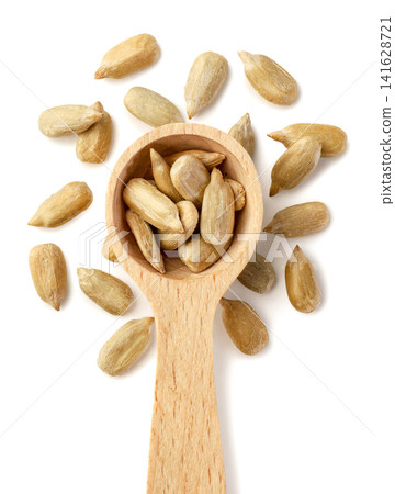 Sunflower seeds in a wooden spoon and scattered isolated on a white background. Top view Sunflower seeds in a wooden spoon and scattered isolated on a white background. Top view 141628721