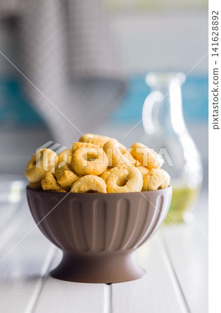 Bowl of Savory Taralli Ring Snacks on White Table with Olive Oil and Rustic Cloth Bowl of Savory Taralli Ring Snacks on White Table with Olive Oil and Rustic Cloth 141628892