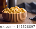 Bowl of Crunchy Taralli Snack Rings on Wooden Table With Bottles in Soft Background 141628897