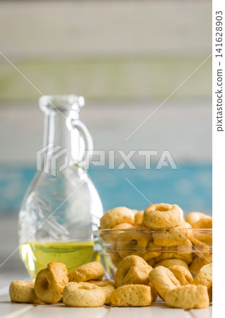Taralli Italian Crackers With Olive Oil in Bowl On Kitchen Table Rustic Savory Snack Taralli Italian Crackers With Olive Oil in Bowl On Kitchen Table Rustic Savory Snack 141628903