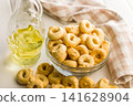 Taralli Italian Crackers With Olive Oil in Bowl On Kitchen Table Rustic Savory Snack 141628904