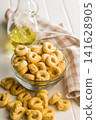 Taralli Italian Crackers With Olive Oil in Bowl On Kitchen Table Rustic Savory Snack 141628905