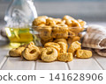 Taralli Italian Crackers With Olive Oil in Bowl On Kitchen Table Rustic Savory Snack 141628906