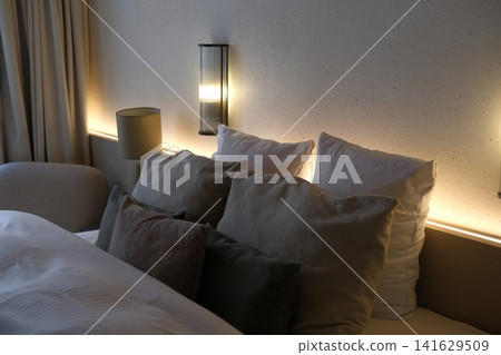 Cozy bedroom with double bed, comforter and pillows in hotel room or apartment. Interior design, vacation and relax. Comfortable space for sleep, home routine 141629509