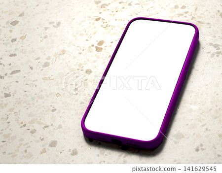 A smartphone with a blank white screen and pink frame lies diagonally on a terrazzo tile floor, A smartphone with a blank white screen and pink frame lies diagonally on a terrazzo tile floor, 141629545
