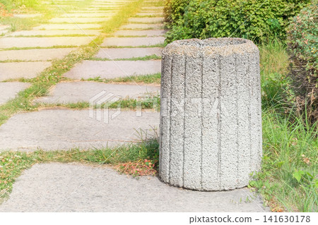 Concrete trash can in a city park. Dumpster being for waste. Sunny day. 141630178