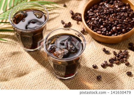 iced coffee poured into a glass iced coffee poured into a glass 141630479