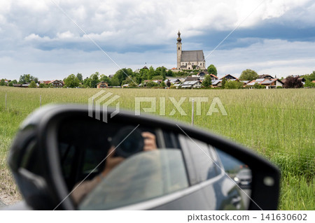 Catholic church of the Assumption of Mary seen from car window while travelling through green fields in rural Bavaria, Germany Catholic church of the Assumption of Mary seen from car window while travelling through green fields in rural Bavaria, Germany 141630602