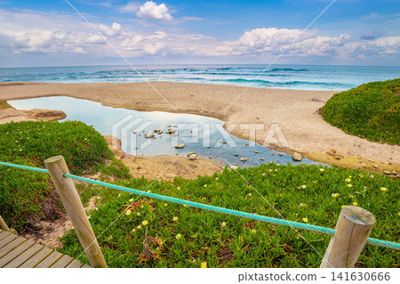 The wooden footpath on the sandy seashore on a sunny day. Porto, Portugal, Europe The wooden footpath on the sandy seashore on a sunny day. Porto, Portugal, Europe 141630666