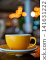 Coffee cup on a table in a cafe with blurred lights in the background 141631222