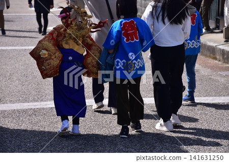 在日本愛知縣犬山市參加犬山春季祭的家庭;一名男孩穿著傳統的金色內衣。 在日本愛知縣犬山市參加犬山春季祭的家庭;一名男孩穿著傳統的金色內衣。 141631250