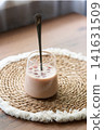Iced cherry juice Bumble coffee in a clear glass on a wooden table. Refreshing summer drink served on a natural woven 141631509