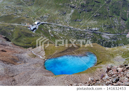 Bright turquoise mountain lake and winding road at Passo della Forcola Bright turquoise mountain lake and winding road at Passo della Forcola 141632453