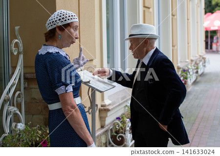 Older couple discussing menu outside a vintage cafe in a charming town during a sunny afternoon Older couple discussing menu outside a vintage cafe in a charming town during a sunny afternoon 141633024