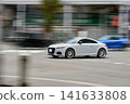 A white coupe speeding through the city streets 141633808