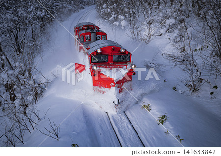 Two snowplows make their way across a snowfield. Two snowplows make their way across a snowfield. 141633842