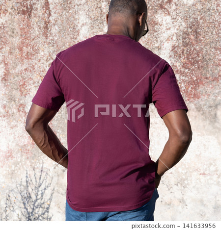 Blank dark red t-shirt mockup on smiling black man outdoors, back view with copy space 141633956