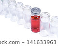 Phial with red vaccine in the row of empty vials 141633963