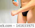 身穿黑色比基尼和防曬乳的男士 141633975