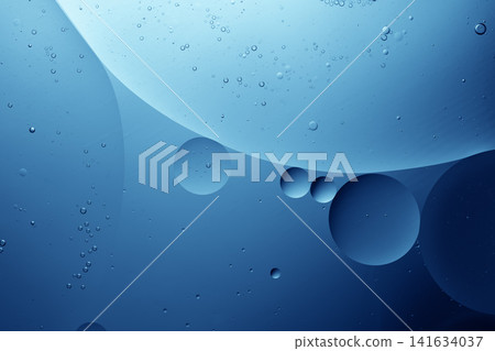 Oil drops creating an abstract blue background in water with bubbles Oil drops creating an abstract blue background in water with bubbles 141634037