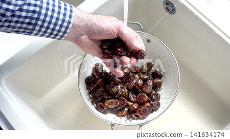 Male hands wash dried dates Male hands wash dried dates 141634174