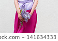 Cute woman holds a vibrant bouquet of lilacs 141634333