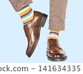 Man in beige pants, striped socks and brown shoes. 141634335