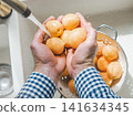 Male hands wash ripe apricots 141634345