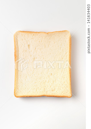 A top-down view of a single slice of 6-slice loaf of bread (square loaf) placed against a white background. A top-down view of a single slice of 6-slice loaf of bread (square loaf) placed against a white background. 141634403