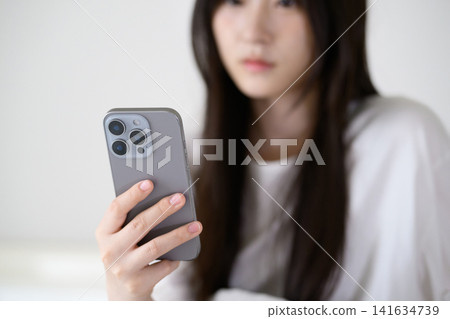 觀看智能手機的婦女 觀看智能手機的婦女 141634739