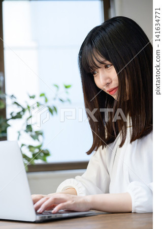 Young businesswoman using laptop in office Young businesswoman using laptop in office 141634771