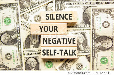 Silence your negative self-talk symbol. Concept words Silence your negative self-talk on beautiful wooden blocks. Beautiful dollar bills background. Psychological negative self-talk concept Copy space Silence your negative self-talk symbol. Concept words Silence your negative self-talk on beautiful wooden blocks. Beautiful dollar bills background. Psychological negative self-talk concept Copy space 141635410