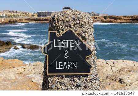 Listen and learn words symbol. Concept words Listen and learn on beautiful black blackboard. Beautiful stone blue sea blue sky background. Business listen and learn support concept. Copy space. Listen and learn words symbol. Concept words Listen and learn on beautiful black blackboard. Beautiful stone blue sea blue sky background. Business listen and learn support concept. Copy space. 141635547