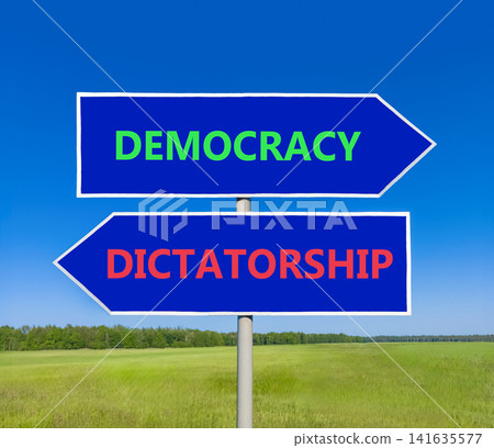 Democracy or dictatorship words symbol. Concept words Democracy Dictatorship on beautiful blue road sign. Beautiful blue sky background. Business democracy dictatorship concept. Copy space Democracy or dictatorship words symbol. Concept words Democracy Dictatorship on beautiful blue road sign. Beautiful blue sky background. Business democracy dictatorship concept. Copy space 141635577