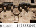Historic stone architecture features detailed carvings from an ancient structure in the sunlight highlighting its weathered surface 141635645