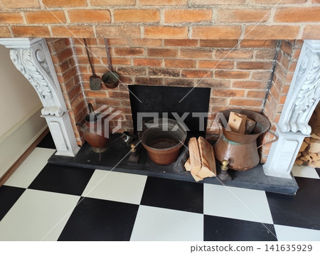 Rustic Brick Fireplace with Vintage Copper Pots, Firewood, and Black and White Checkered Floor Tile Rustic Brick Fireplace with Vintage Copper Pots, Firewood, and Black and White Checkered Floor Tile 141635929