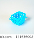 Small light blue plastic toy basket with star-shaped cutouts and handles, isolated on a white background. Perfect for shopping concepts, miniature decor, or children play imagery and retail design. 141636008