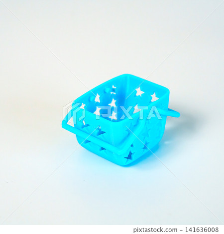 Small light blue plastic toy basket with star-shaped cutouts and handles, isolated on a white background. Perfect for shopping concepts, miniature decor, or children play imagery and retail design. Small light blue plastic toy basket with star-shaped cutouts and handles, isolated on a white background. Perfect for shopping concepts, miniature decor, or children play imagery and retail design. 141636008