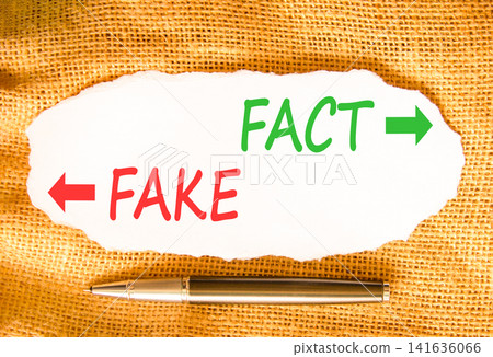 Fact or fake words symbol. Concept words Fake and Fact on beautiful white paper. Beautiful canvas background. Business and fact or fake concept. Copy space. Fact or fake words symbol. Concept words Fake and Fact on beautiful white paper. Beautiful canvas background. Business and fact or fake concept. Copy space. 141636066