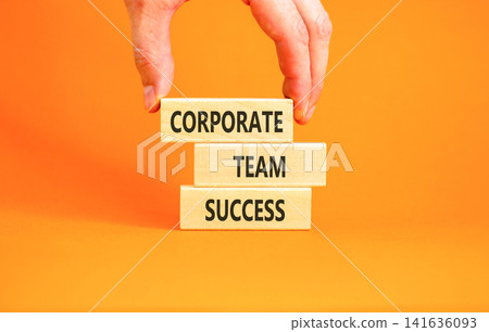 Corporate team success words symbol. Concept words Corporate team success on beautiful wooden blocks. Beautiful orange background. Businessman hand. Business corporate team success concept Copy space 141636093
