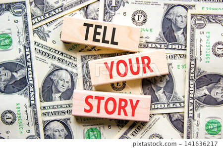 Tell your story symbol. Concept word Tell your story on beautiful wooden blocks. Beautiful dollar bills background. Dollar bills. Business tell your story concept. Copy space. Tell your story symbol. Concept word Tell your story on beautiful wooden blocks. Beautiful dollar bills background. Dollar bills. Business tell your story concept. Copy space. 141636217