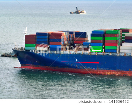 Aerial view of container cargo ship at sea. International shipping and logistics. Maritime freight transportation. Global trade and export import industry. Commercial vessel carrying containers. Aerial view of container cargo ship at sea. International shipping and logistics. Maritime freight transportation. Global trade and export import industry. Commercial vessel carrying containers. 141636432
