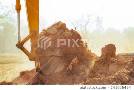 Closeup bucket of backhoe digging the soil at construction site. Crawler excavator digging on demolition site. Excavating machine. Earth moving equipment. Excavation vehicle. Construction business. Closeup bucket of backhoe digging the soil at construction site. Crawler excavator digging on demolition site. Excavating machine. Earth moving equipment. Excavation vehicle. Construction business. 141636454