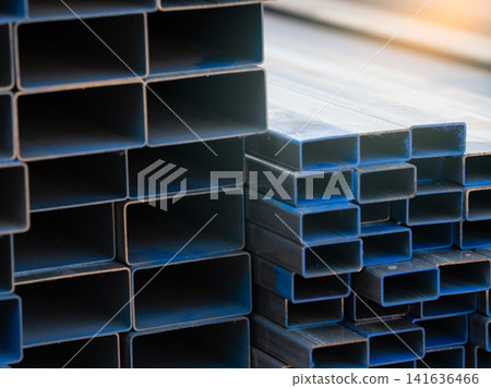 Industrial warehouse stock of rectangular metal pipes for building and construction supplies. Stack of steel pipes. Iron materials for construction and infrastructure projects. Steel tubing storage. Industrial warehouse stock of rectangular metal pipes for building and construction supplies. Stack of steel pipes. Iron materials for construction and infrastructure projects. Steel tubing storage. 141636466
