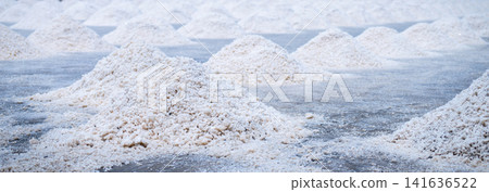 Sea salt farm. Pile of brine salt. Raw material of salt industrial. Sodium Chloride mineral. Evaporation and crystallization of sea water. White salt harvesting. Agriculture industry. Traditional farm Sea salt farm. Pile of brine salt. Raw material of salt industrial. Sodium Chloride mineral. Evaporation and crystallization of sea water. White salt harvesting. Agriculture industry. Traditional farm 141636522